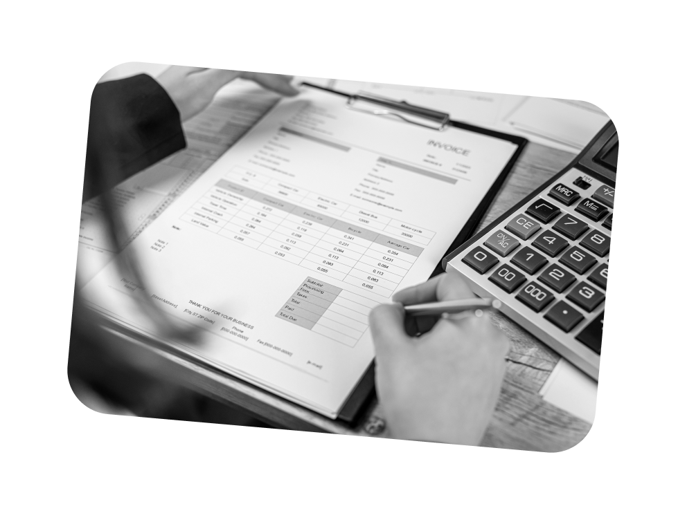 Person überprüft eine Rechnung mit Taschenrechner auf einem Schreibtisch