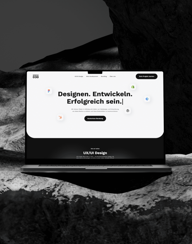 Laptop mit Website für Designagentur auf Felsen, Schwarz-Weiß-Umgebung